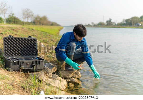 A technician use the Professional Water Testing\
equipment to measure the water quality at the public canal.\
Portable multi parameter water quality measurement. Water quality\
monitoring concept.