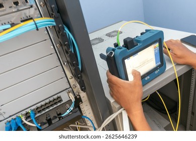 A technician uses specialized cable testing equipment to assess network performance and maintain connectivity in a data center environment.