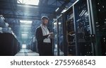 Technician uses tablet in a data center to analyze the server.