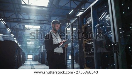 Technician uses tablet in a data center to analyze the server.