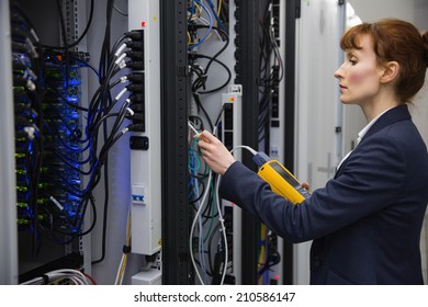 Technician using digital cable analyzer on server in large data center - Powered by Shutterstock