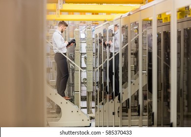 Technician using digital cable analyzer in server room