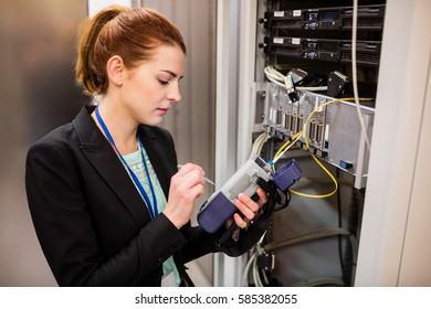 Technician using digital cable analyzer in server room