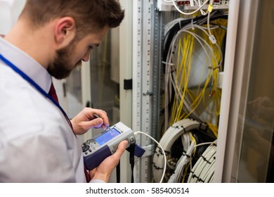 Technician using digital cable analyzer in server room