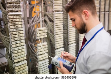 Technician using digital cable analyzer in server room