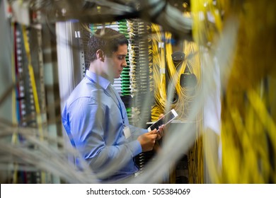 Technician using digital tablet in server room