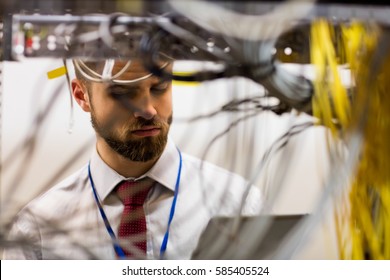 Technician using digital tablet while analyzing server in server room