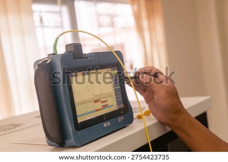 A technician using a digital testing device to monitor and assess performance. The screen displays real-time data during a crucial testing process.