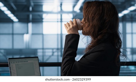 Technician using laptop in data center, finetuning network protocols, holding coffee cup. Woman in server room coding on notebook, enforcing advanced security measures, camera A