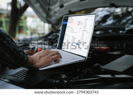 Technician using a laptop to diagnose engine performance under an open hood, analyzing vehicle data and troubleshooting automotive issues with digital diagnostic software.