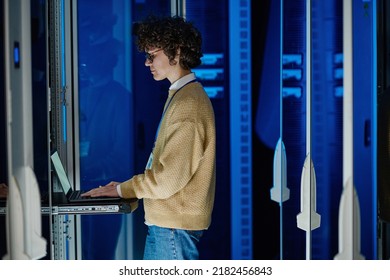 Technician Using Laptop In Large Data Center