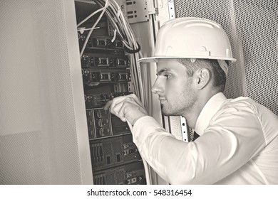 Technician using laptop in modern server room at the data centre