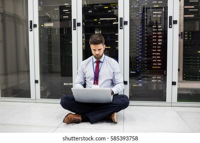 Technician Using Laptop In Server Room