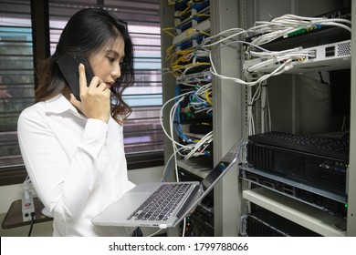 Technician using laptop while analyzing server in data center.