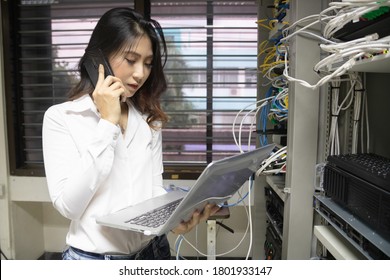 Technician using laptop while analyzing server in data center.