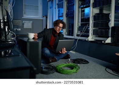 IT technician using laptop while working in data center