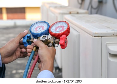 Technician Using Manifold Gauge Is Measuring Equipment For Filling Industrial Factory Air Conditioners And Checking Maintenance Outdoor Air Compressor Unit.