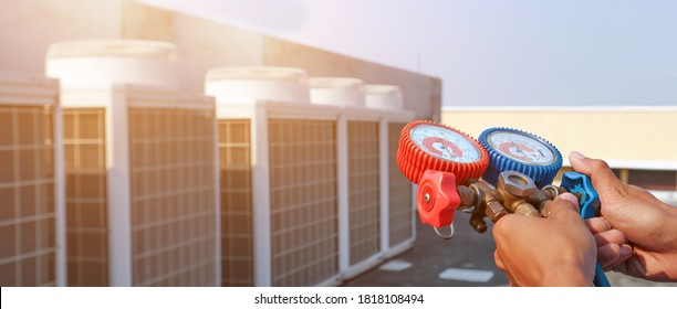 Technician Using Manifold Gauge Is Measuring Equipment For Filling Industrial Factory Air Conditioners After Cleaning And Checking For Maintenance Outdoor Air Compressor Unit.