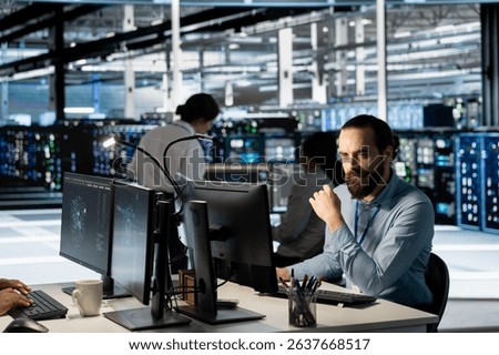Technician using PC in data center to update server tech, configuring equipment using software tools. Server room employee reviewing hardware analytics, ensuring reliable network operations