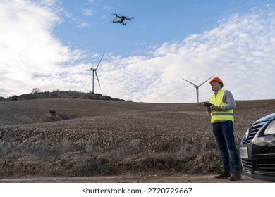 Technician using a remote control for drone inspection of wind turbines in a rural landscape, symbolizing energy innovation and maintenance