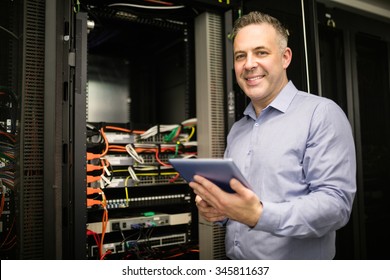 Technician using tablet pc while analysing server at the data centre