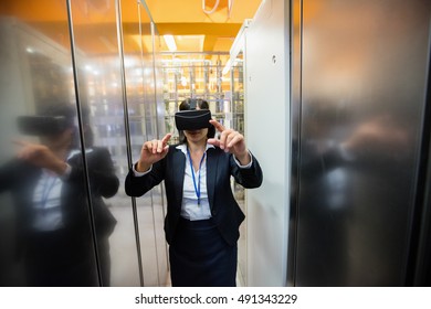 Technician using visual reality headset in hallway of server room