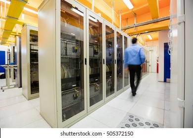Technician walking in corridor of server room