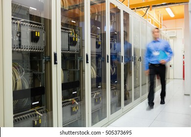 Technician walking in corridor of server room