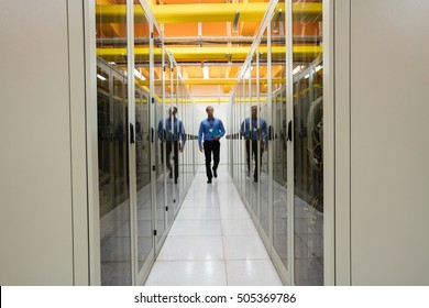 Technician walking in hallway of server room