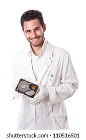 a technician wearing lab coat holding an hard disk drive
