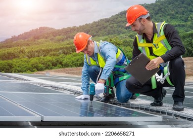 Technician Wearing Safety Harness Belt Using Drill During Installing The Solar Panels On Roof Structure Of Building Factory.