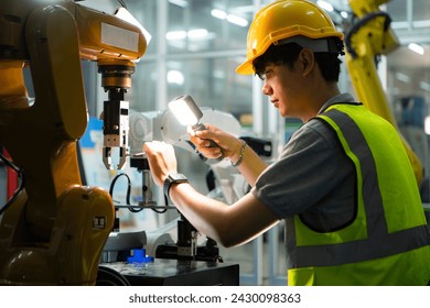 Technician who maintains a small robot arm the operation of a small robot arm used in industry is being repaired.