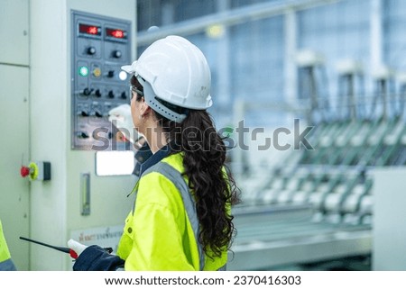 technician woman engineer checking process on control panel. work with machinery equipment plant technology. smart industry worker operating. Factory woman standing confident at heavy machine.