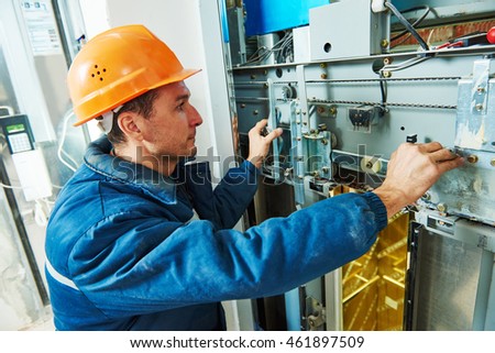 technician worker adjusting elevator mechanism of lift