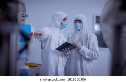 Technician Worker Wearing Protective Suite , Glove Are Inspect Ion With Check  Face Mask Manufacturing Process To Safe And Against From Virus. 