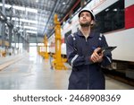 Technician or worker writing and checking on clipboard at train construction site