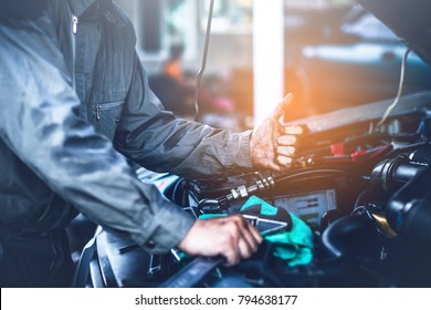 technician working on checking and service car in  workshop garage; technician repair and maintenance engine of automobile in car service