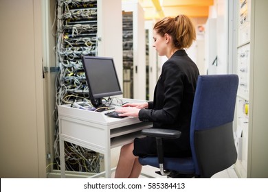 Technician working on computer in server room