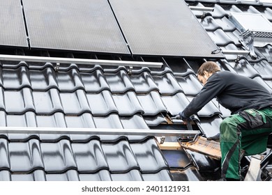 Technician Working on the Mounting Structure for Solar Panels on the Roof of a House 
