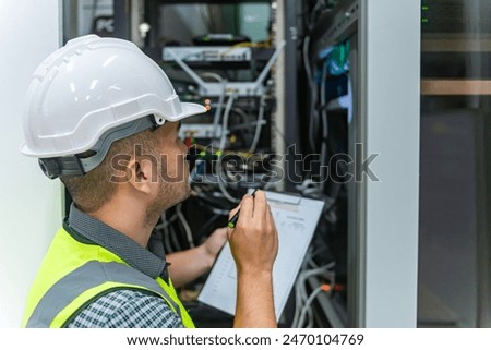 an IT technician working on network Internet cables and servers and try to checklist on the paper