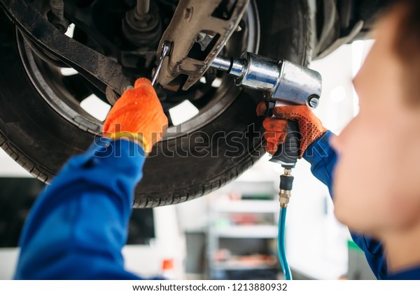 Technician with a\
wrench repair car\
suspension