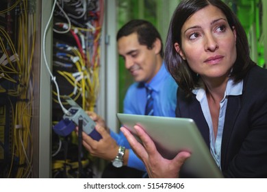 Technicians analyzing rack mounted server in server room