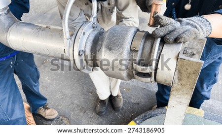Technicians assembling industrial pipe coupling with tools, showing engineering maintenance process and mechanical workflow.