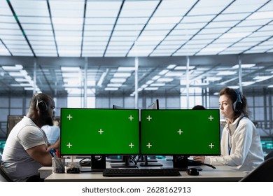Technicians in data center listening music, optimizing IT infrastructure using green screen PCs. Server room experts wearing headphones upgrading gear with chroma key computers, reducing costs