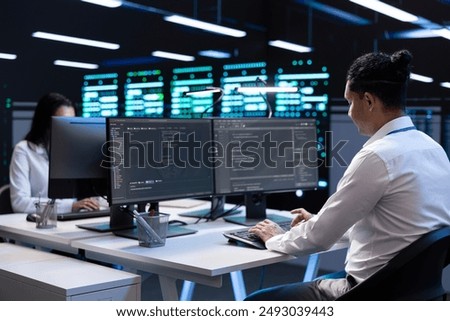 Technicians in data center workspace running system diagnostic tests and error checking utilities to fix problems. Employees looking for network issues affecting rigs performance and connectivity