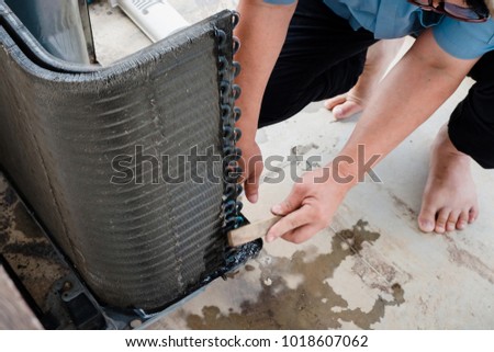 Technicians fix air-condition problem at home. In this case, coil piping is leak. Refrigerant will evaporate from system and compressor will working fail by indoor unit spray a ice instead cool wind.