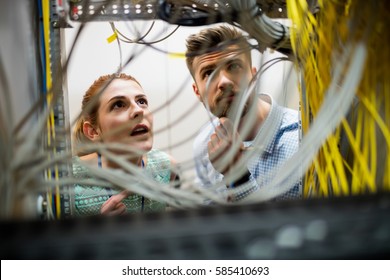 Technicians fixing cable in server room