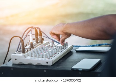 Technician's Hand Tuning Adjustment On Audio Control Panel In Booth At The Audio System Equipment And Control Panel Of Digital Studio Mixer. Hand Tuning Sound Control Knob On Amplifier.