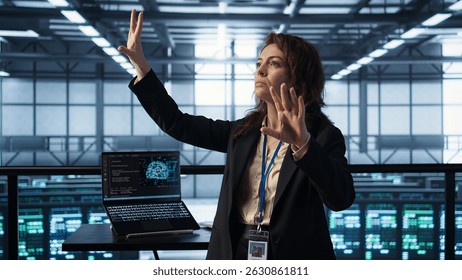 Technicians in high tech AI data center workspace looking at hologram visualization. Programmer working on securing server room hardware using AR artificial intelligence tech, camera B