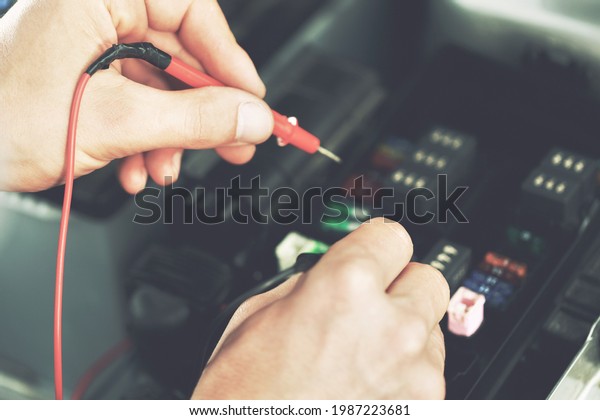 Technicians inspect the car\'s automobile\
electrical system.